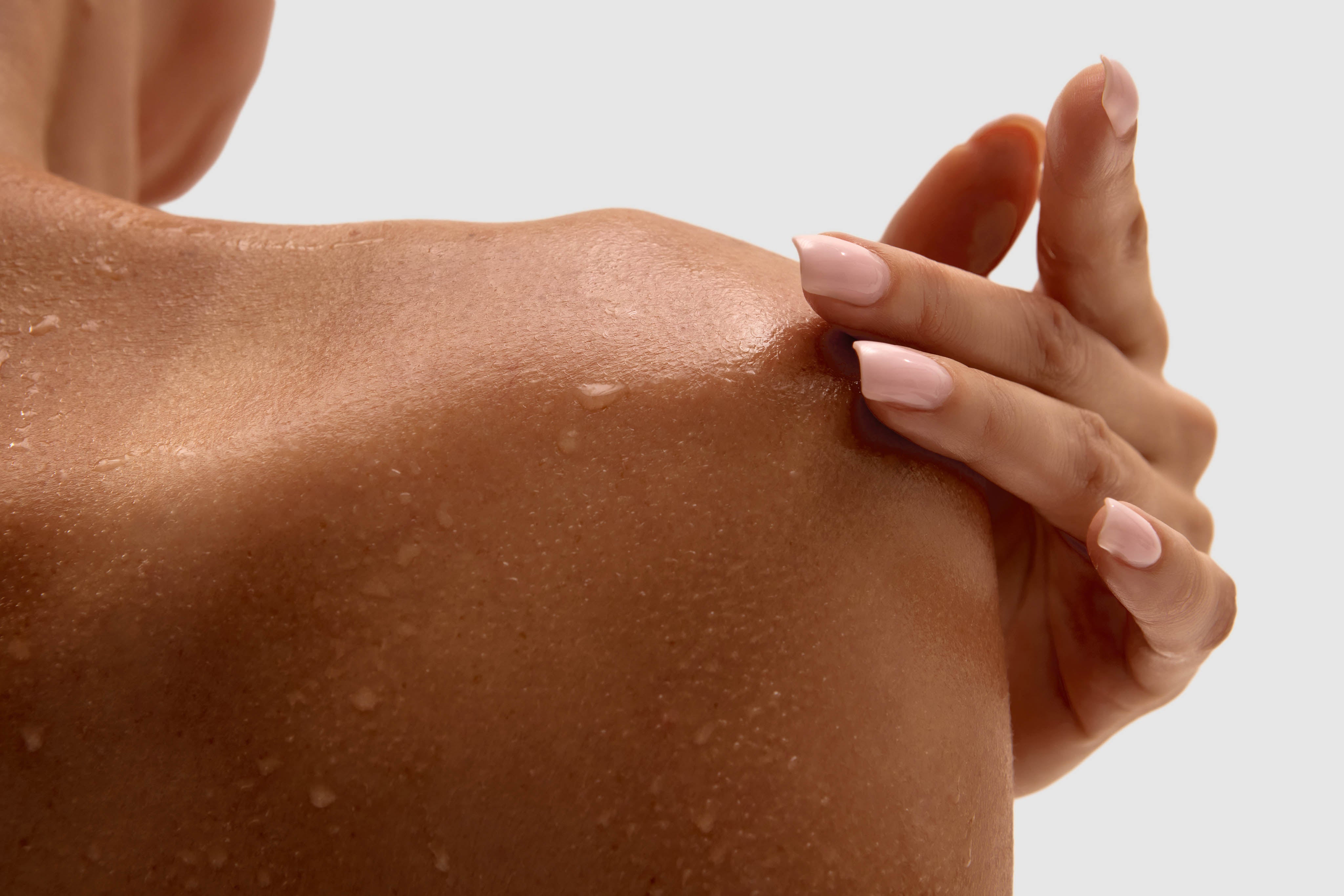 Body skincare being applied to a shoulder