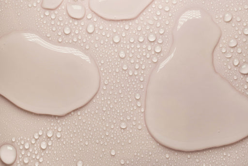 Rose-colored skincare serum droplets